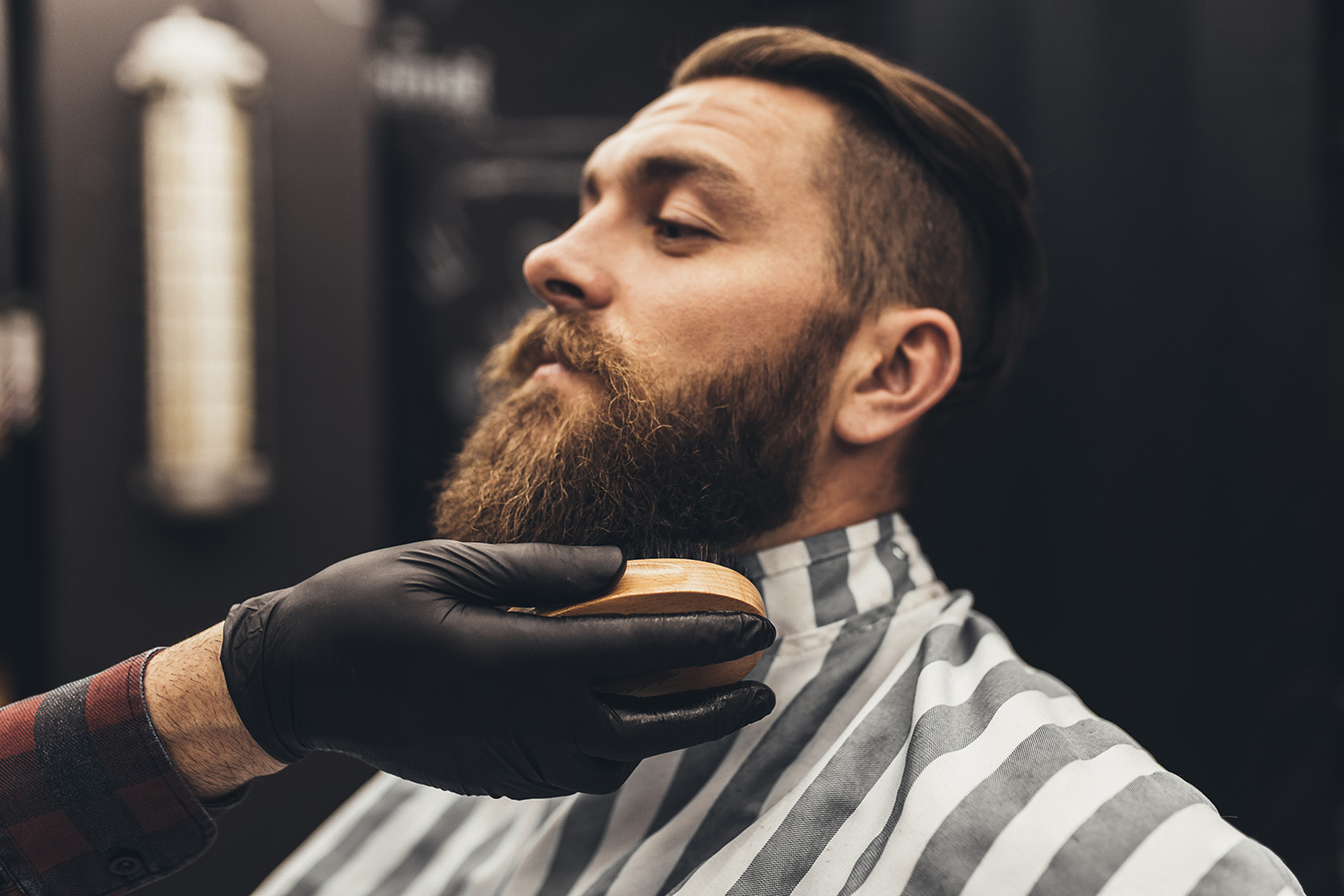 Hipster young good looking man visiting barber shop. Trendy and